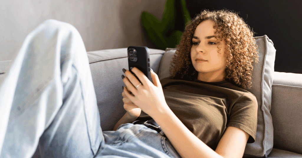 Woman researching open adoption and learning about her pregnancy options on her phone.
